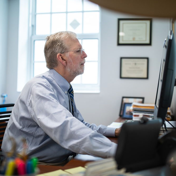 Loring Ingraham working at a desk in his office
