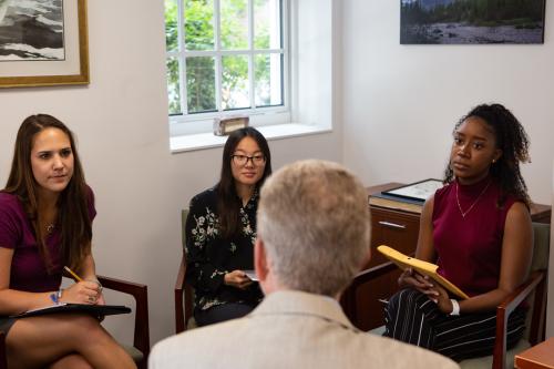 Three students learning from an instructor